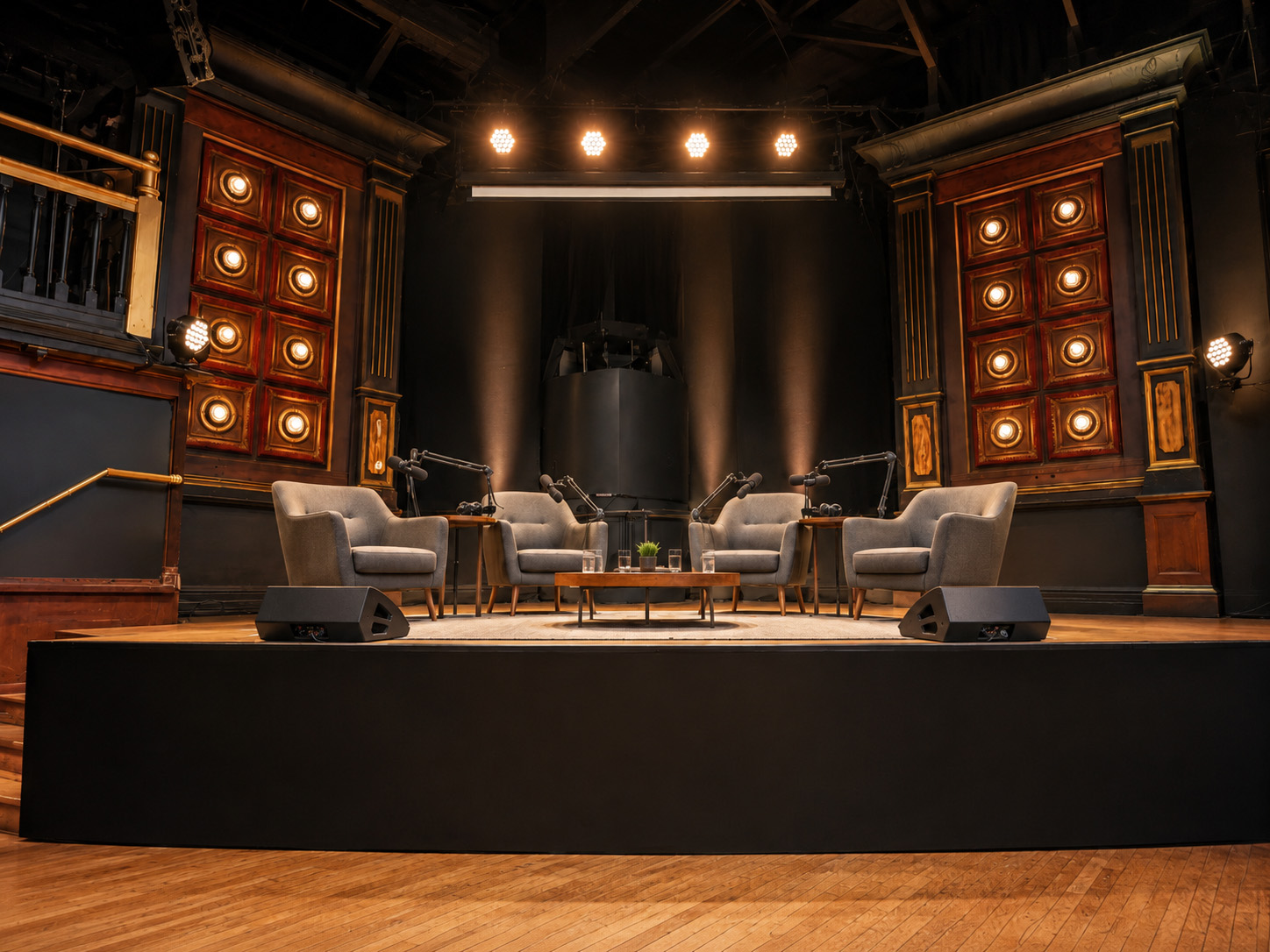 Armchairs and microphones set for a conversation on the theatre stage