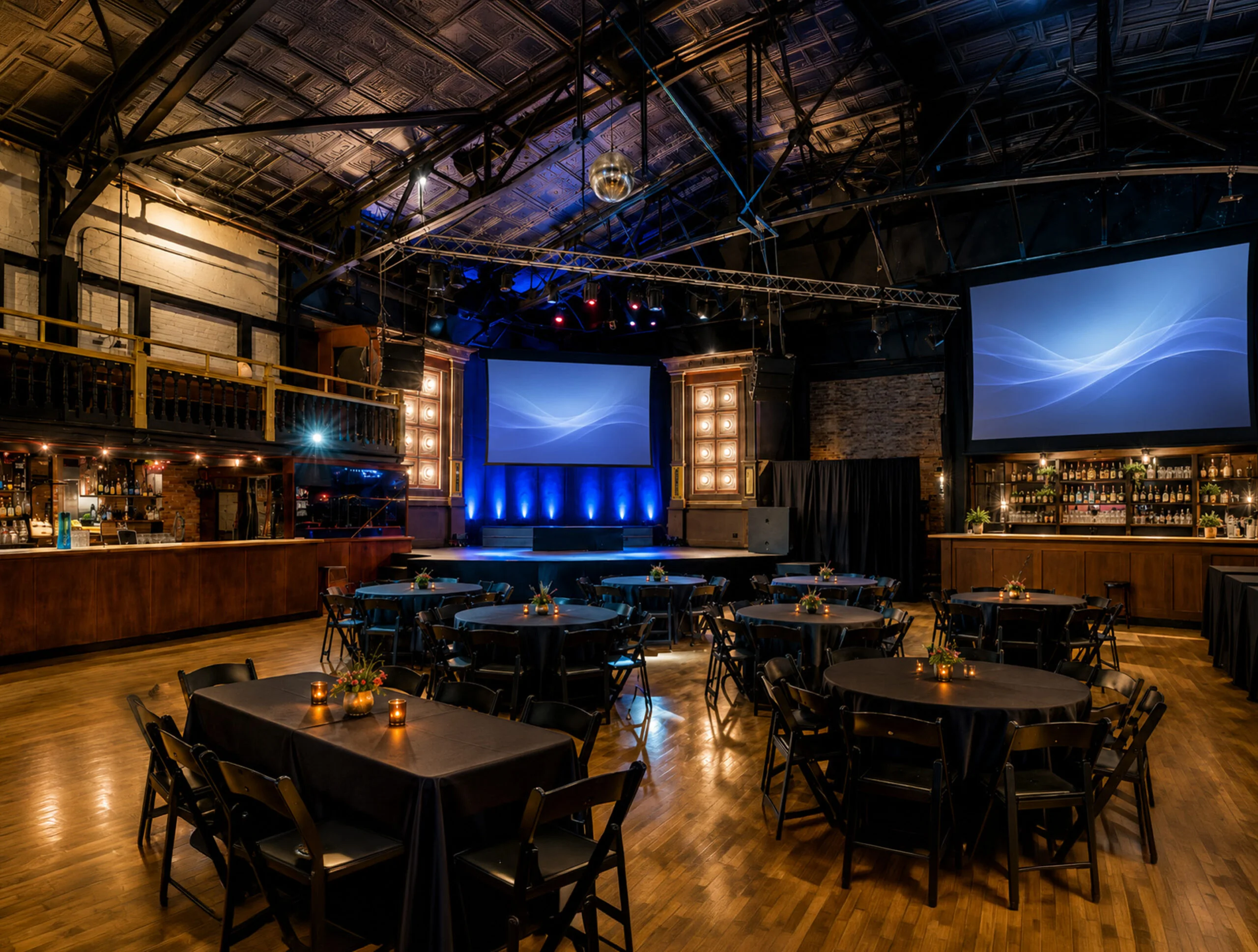 Round tables arranged in the theatre with blue stage lighting